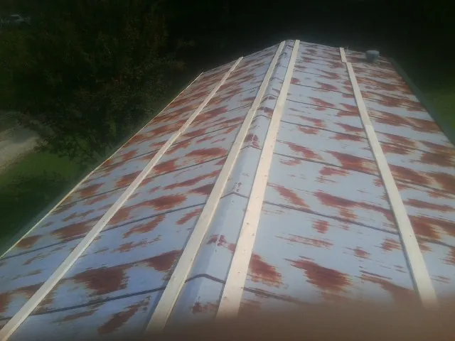 Rusted metal roof panels with new wood purlins before replacement — Storm Damage Roof Repair in Stewartsville by Roofing Brothers